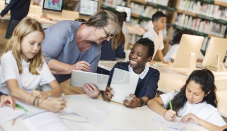 Foto de Grupo de niños que estudian en la biblioteca con el profesor, Educación y Concepto de la infancia. Fotoset original - Imagen libre de derechos