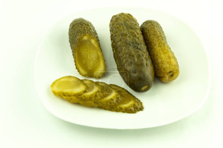 Photo for Canned cucumbers in a plate on a white background. Pickled and crunchy cucumbers, delicious pickled cucumbers - Royalty Free Image