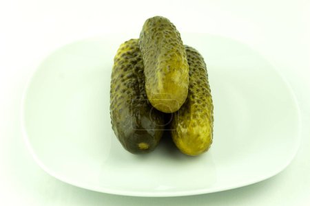 Photo for Canned cucumbers in a plate on a white background. Pickled and crunchy cucumbers, delicious pickled cucumbers - Royalty Free Image