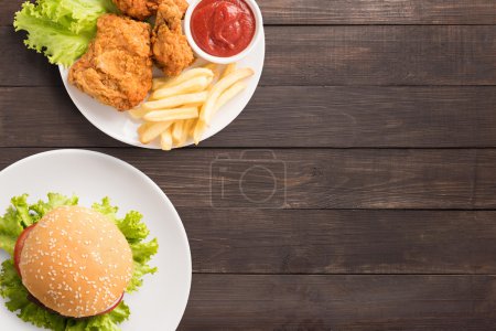 Set de comida rápida pollo frito, papas fritas y hamburguesa en madera
