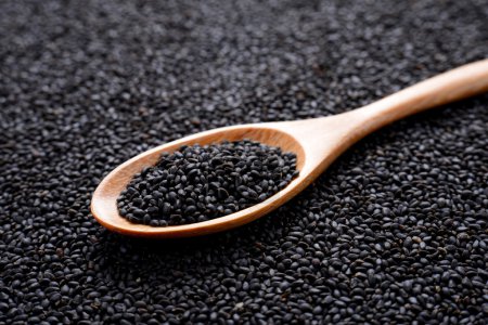 Photo for Black sesame  in wooden spoon on sesame background. - Royalty Free Image