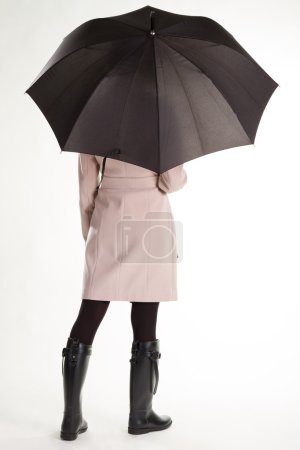 Téléchargez les photos : Jeune fille en bottes de caoutchouc et parapluie tourne le dos. Fille sous la pluie. - en image libre de droit