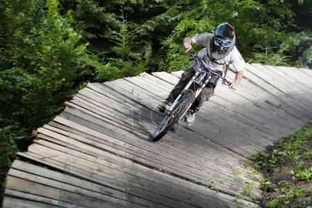 Photo for Mountainbiker rides on wooden platform - Royalty Free Image