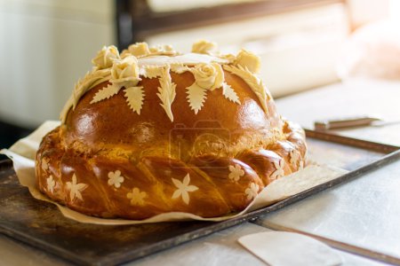 Téléchargez les photos : Pain de mariage sur le plateau du four. Produit de boulangerie avec décoration. Traditions de la patrie. Inviter des invités pour les vacances
. - en image libre de droit