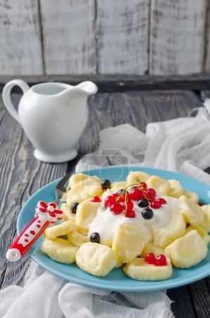 Lazy dumplings of cottage cheese with sour cream and berries