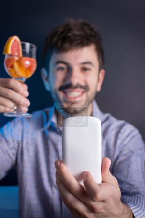 Loco haciendo una selfie con un cóctel
