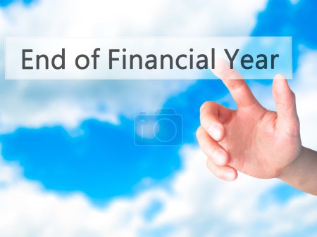 Photo for End of Financial Year - Hand pressing a button on blurred background concept . Business, technology, internet concept. Stock Photo - Royalty Free Image