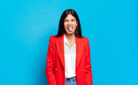 joven empresaria hispana sintiéndose disgustada e irritada, sacando la lengua, detestando algo desagradable y asqueroso joven empresaria hispana sintiéndose disgustada e irritada, sacando la lengua, detestando algo desagradable y asqueroso