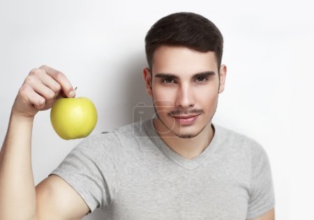 Téléchargez les photos : Jeune homme beau tenant une grosse pomme verte mûre. Style de vie sain, publicité sociale, bonne nutrition, digestion des soins, programme de régime alimentaire. Studio gros plan portrait, garçon mannequin, homme, courageux, puissant - en image libre de droit