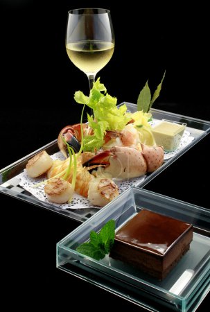 Photo for Crab claws, lobster tails and braised scallions with white wine and chocolate mousse - Royalty Free Image