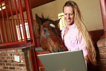 Photo for Blonde girl and her horse check their social media site - Royalty Free Image