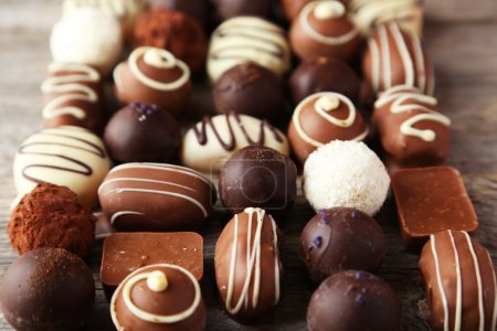 Foto de Chocolates sabrosos y dulces sobre fondo de madera gris - Imagen libre de derechos