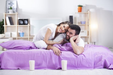 Feliz joven pareja en la cama sofá en habitación ded
Feliz joven pareja en la cama sofá en habitación ded