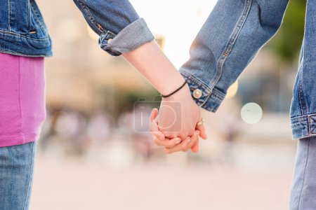 Photo for Two female date taking by the hand, multiethnic girlfriends walking together - Royalty Free Image