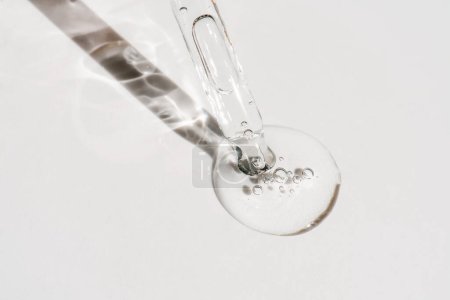 A drop of cosmetic oil falls from the pipette