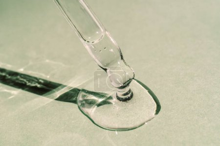 A drop of cosmetic oil falls from the pipette