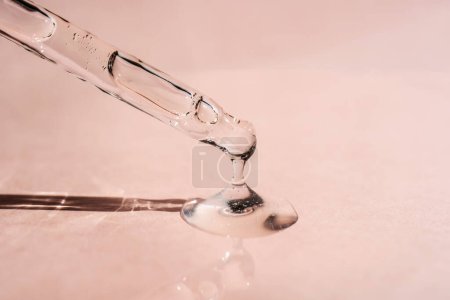 A drop of cosmetic oil falls from the pipette