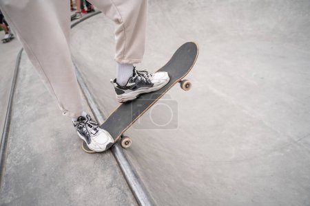 Teilansicht eines Mannes in Turnschuhen beim Skaten auf Skaterrampe