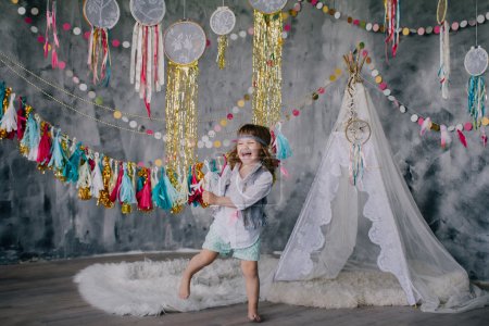 Photo for Stylish studio photoshoot with boho decorations - dreamcatchers, tipi, garlands and guitars - Royalty Free Image