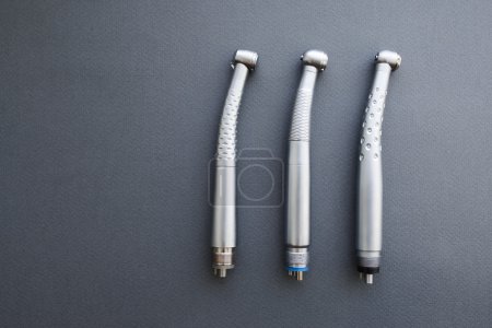 Photo for Dental turbine handpieces without burs copyspace. Horizontal line of dental turbine handpieces without burs at right side. Flat lay of dental turbine handpieces without burs on gray background - Royalty Free Image