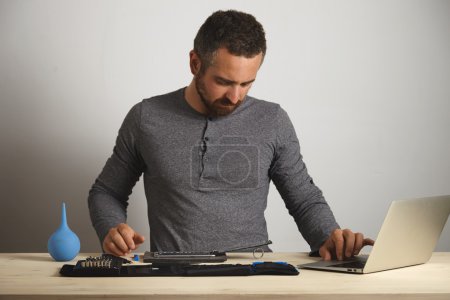 man looking at disassembled phone