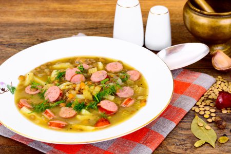 Foto de Comida saludable y dietética: Sopa con lentejas, apio y salchicha en blanco Plate Studio Photo - Imagen libre de derechos