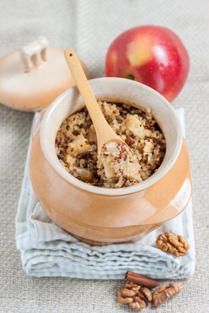 Téléchargez les photos : Bouillie de quinoa aux pommes, noix, cannelle et lait dans une casserole - en image libre de droit