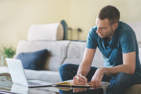 Foto de Joven que trabaja en casa usando la computadora - Imagen libre de derechos