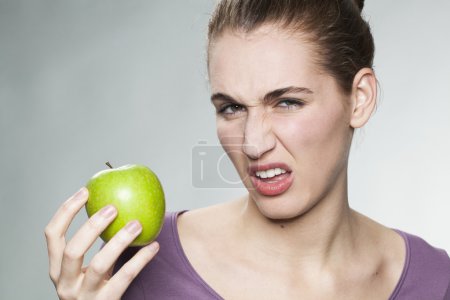 unhappy 20s woman developing aversion for perfect looking fruits