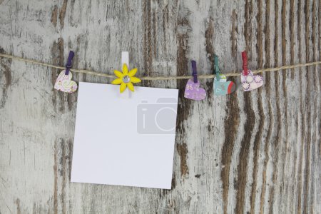 Photo for Empty note hanging with a clothespin, in a wood background - Royalty Free Image