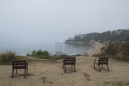 Photo for Three empty chairs in the coast, in a misty winter day - Royalty Free Image