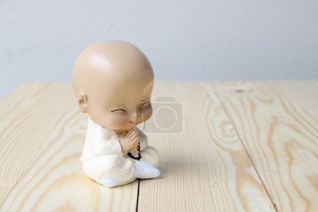 Photo for Little monk's praying, Statue neophyte on pine wood background - Royalty Free Image