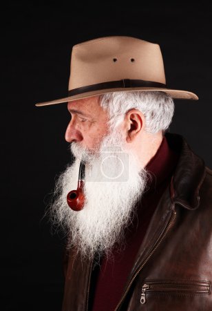 Hombre barbudo con sombrero y pipa de tabaco
