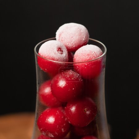 Foto de Cereza congelada en la copa de vino, baya fría en la mesa de madera - Imagen libre de derechos