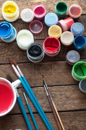 Photo for Art of Painting. Paint buckets on wood background. Different paint colors painting on wooden background. Painting set: brushes, paints, crayons, chalk, watercolor, acrylic paint on a wooden backgroun - Royalty Free Image