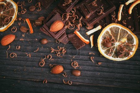 Copa de chocolate caliente, limón, nueces y surtido de chocolates finos en negro, y chocolate con leche

