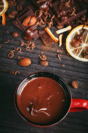 Copa de chocolate caliente, limón, nueces y surtido de chocolates finos en negro, y chocolate con leche
