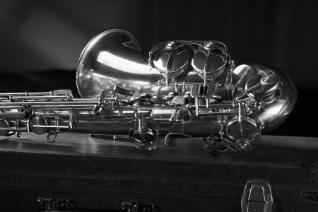 Photo for Old saxophone lying on the suitcase, a black-and-white photography. - Royalty Free Image