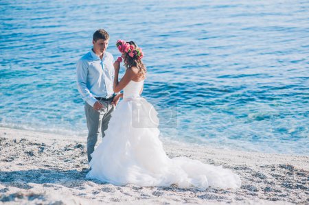 Novia y novio junto al mar

