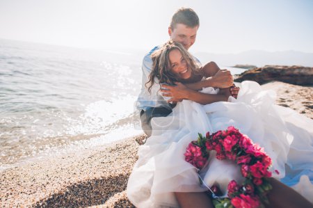 Novia y novio junto al mar
