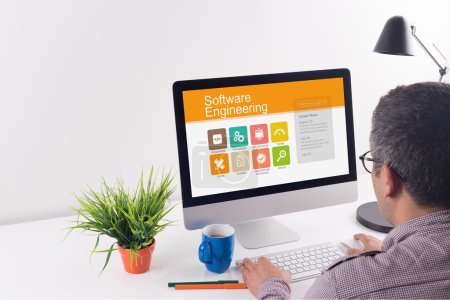 Photo for Man working on computer at desk in modern office with text software engineering - Royalty Free Image