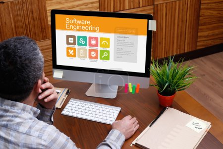 Photo for Man working on computer at desk in modern office with text software engineering - Royalty Free Image