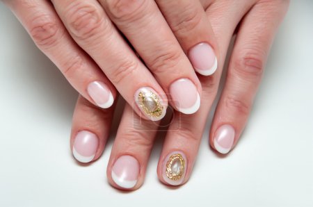 manicura francesa de boda con broche de camafeo de piedra líquida en el dedo anular
