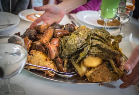 Photo for Traditional Furnas stew which is cooked for many hours in the volcanic vents in the ground. It consists of various meats - chicken, beef, pork, chorizo, lamb as well as potatoes and cabbage - Royalty Free Image