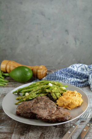 Foto de Chuletas de cerdo keto con judías verdes, aguacate y mantequilla de ajo - Imagen libre de derechos