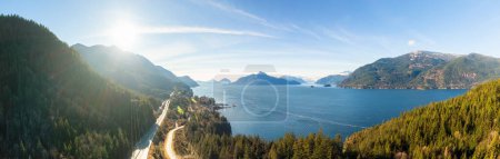 Photo for Aerial panoramic view of the Sea to Sky Highway in Howe Sound, North of Vancouver, British Columbia, Canada. Taken during a sunny winter day. - Royalty Free Image